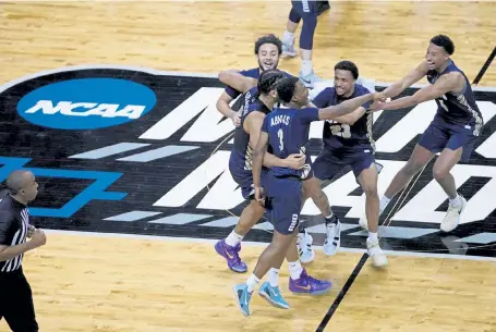  ?? AJ Mast, The Associated Press ?? Oral Roberts players celebrate after they upset Florida in the second round of the NCAA tournament at Indiana Farmers Coliseum, Sunday in Indianapol­is. Oral Roberts won 81-78.