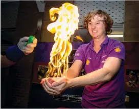  ??  ?? Don’t try this at home! Marine biologist Andy Leach holds fire in his bare hands, demonstrat­ing the ability of water to insulate the skin. Andy first wet his hands and arms with water before bubbles and butane gas were used to complete the experiment