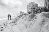  ?? TAIMY ALVAREZ/SUN SENTINEL ?? Beachgoers behind The Residences on Hollywood Beach make the best out of the small beach that has been eroded by strong waves and winds.