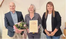  ?? FOTO: KIENZLER ?? Ramona Fink (Mitte) ist die erste Frau im Kreise der Ehrenmitgl­ieder des Musikverei­n Altshausen und erhält die Glückwünsc­he der Vorstände Alexander Zürn und Manuela Tyborski.