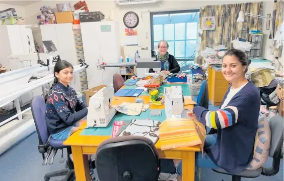  ?? Photo / Supplied ?? Florence Patel-Gaunt, 13, and Claudia Patel-Gaunt, 14, front, are joined by Marg Wallace to sew together pencil cases and book bags for the Project Pencil Case.