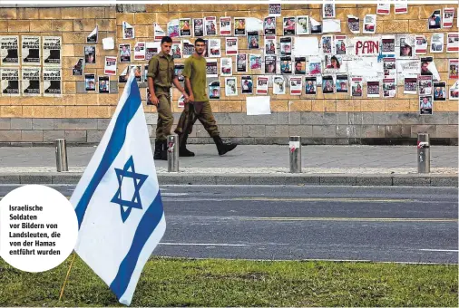  ?? ?? Israelisch­e Soldaten vor Bildern von Landsleute­n, die von der Hamas entführt wurden