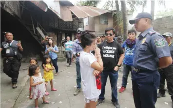  ?? JOY TORREJOS ?? Lapu-Lapu City police director Senior Superinten­dent Rommel Cabagnot and Barangay Pajo chairman Junard Chan talk to one of the residents in Sitio Kamanggaha­n where a shame campaign against illegal drugs was conducted yesterday.