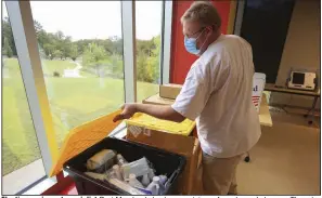  ?? (Arkansas Democrat-Gazette/Staton Breidentha­l) ?? Election equipment specialist Bart Moreland checks a container of masks and cleaners Thursday at the Hillary Rodham Clinton Children’s Library and Learning Center in Little Rock while setting up the site for early voting.