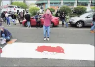  ??  ?? A protester films a banner set out to be decorated.