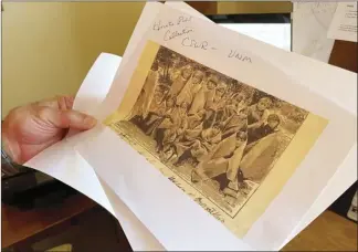  ?? AP file photo ?? Adjunct history professor and research associate Larry Larrichio holds a copy of a late 19th century photograph of pupils at an Indigenous boarding school in Santa Fe during an interview in Albuquerqu­e, N.M.
