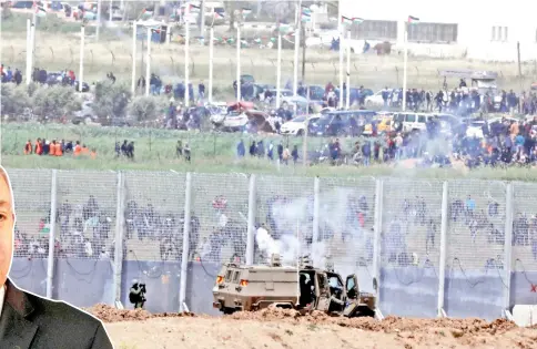  ??  ?? Israeli army clash with Palestinia­n protesters over the border between Israel and the Gaza Strip. — Reuters photo