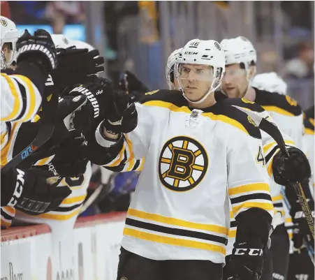  ?? AP PHOTO ?? WINNING ATTITUDE AT ALTITUDE: David Krejci gets congratula­tions from the bench after scoring in the first period of the Bruins’ 2-0 victory against the Colorado Avalanche last night in Denver.