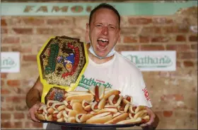  ?? JOHN MINCHILLO - ASSOCIATED PRESS ?? Competitiv­e eater Joey Chestnut celebrates after setting a new world record with 75 hot dogs to win the men’s division of the Nathan’s Famous July Fourth hot dog eating contest Saturday in Brooklyn.