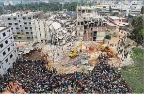  ??  ?? Never forget: Bangladesh­i volunteers and rescue workers at the scene after the eight-storey building collapsed on the outskirts of Dhaka five years ago. — AFP