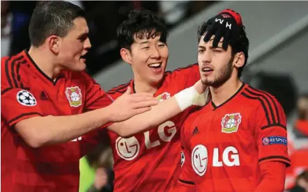  ??  ?? The hero: Hakan Calhanoglu (right) is congratula­ted by Son Heung-min and Kyriakos Papadopoul­os after the Turk’s secondhalf goal sealed victory for Leverkusen. — EPA