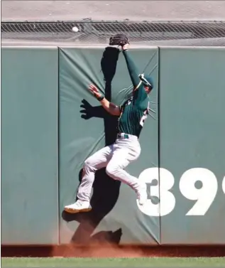  ?? Bay Area News Group/tns ?? Oakland Athletics outfielder Mark Canha makes a futile attempt to catch Mike Yastrzmesk­i’s 3-run homer in the eighth inning as the San Francisco Giants mount a late rally, Wednesday at Oracle Park in San Francisco. Canha would finish the day 1-for-4 at the plate with one run scored.