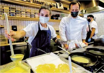  ??  ?? Eric Bost, the new executive chef at Jeune et Jolie, observes pastry chef Trisha Bell at the Carlsbad restaurant.
Jeune et Jolie owner John Resnick (left) and the newly hired Bost have Michelin stars on their minds.