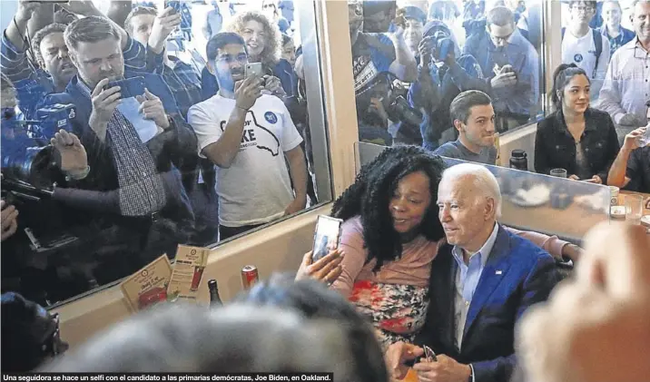  ??  ?? Una seguidora se hace un selfi con el candidato a las primarias demócratas, Joe Biden, en Oakland.