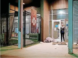  ?? [PHOTO BY STEVE SISNEY, THE OKLAHOMAN] ?? A homeless person sleeps next to the front door of the Homeless Alliance’s WestTown Resource Center on Thursday morning as volunteers arrive to conduct an annual census of Oklahoma City’s homeless population.