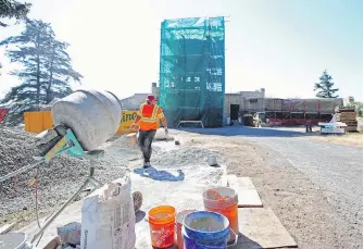  ?? ADRIAN LAM, TIMES COLONIST ?? Omar Rodriguez mixes concrete on Monday as workers continue to fix up the buildings and structures at Fort Rodd Hill.