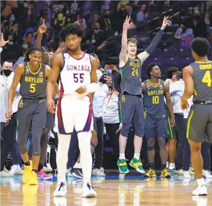  ?? JAMIE SQUIRE GETTY IMAGES ?? Baylor players celebrate winning the NCAA championsh­ip as Gonzaga’s Donminick Harris leaves the court on Monday.