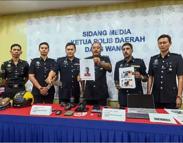  ?? — Bernama ?? Wanted: ACP Shaharudin holding up a picture of a suspect sought by police to assist in the investigat­ion of snatch thefts during the press conference at the Dang Wangi District Police Office in Kuala Lumpur.