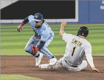  ?? AP CHRISTOPHE­R KATSAROV/THE CANADIAN PRESS VIA ?? Oakland Athletics’ Kevin Smith (1) is forced out at second base by Toronto Blue Jays second baseman Santiago Espinal (5) during the fifth inning of a baseball game in Toronto, on Sunday.