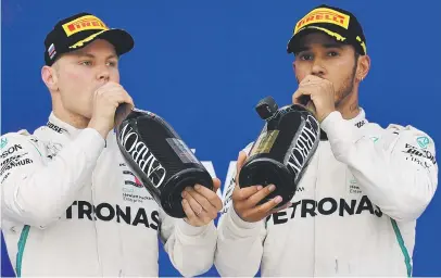  ?? Picture: AFP ?? DRINK UP. Lewis Hamilton (right) and Valtteri Bottas completed a one-two finish for Mercedes in the Russian Formula One Grand Prix at the Sochi Autodrom yesterday.