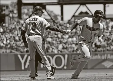  ?? MARCIO JOSE SANCHEZ / THE ASSOCIATED PRESS ?? The Twins’ Eduardo Escobar, right, shakes hands with third-base coach Gene Glynn after hitting a home run against the Giants during the second inning Sunday in San Francisco.