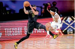 ?? AP ?? Anthony Davis (left) of Los Angeles Lakers saves a ball from going out of bounds in front of Gary Harris of Denver Nuggets during their NBA conference final playoff match in Lake Buena Vista, Florida, on Sunday. The Lakers won 105-103. —
