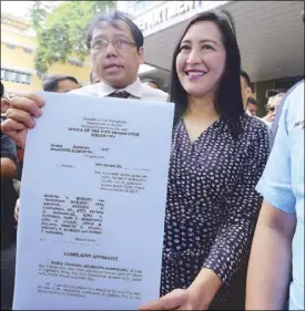  ?? BOY SANTOS ?? Quezon City Vice Mayor Joy Belmonte shows a copy of the libel suit she filed before the city prosecutor’s office yesterday against former Philippine Charity Sweepstake­s Office chief Manuel Morato and several others over an article published in the tabloid Saksi Ngayon.