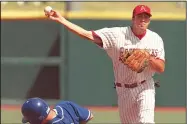  ?? File Photo/Arkansas Democrat-Gazette ?? Arkansas’ Travis McDaniel (right) makes a throw to first base after recording a force out at second base against Kentucky on April 10, 1999, at Baum Stadium in Fayettevil­le.