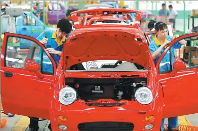  ?? LAN SHAN / FOR CHINA DAILY ?? Workers assemble new-energy cars at a workshop of Weidong New-Energy Car Co Ltd in Zouping, Shandong province.