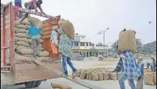  ?? HT FILE PHOTO ?? Labourers loading paddy onto a truck at Bhagtanwal­a grain market in Amritsar in October last year.