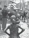  ?? JEWEL SAMAD, AFP/ GETTY IMAGES ?? Uninvited, Fearless Girl faces Charging Bull on Wall Street.