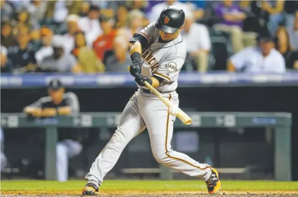  ?? Justin Edmonds, Getty Images ?? Giants second baseman Joe Panik hits an RBI double during the fourth inning Wednesday night at Coors Field, giving San Francisco a 5-0 lead over the Rockies. Panik went 5-for-6 with two doubles, two RBIs and three runs scored to lead the Giants to an...