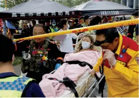  ?? ?? UNA MUJER herida es llevada a revisión médica tras su rescate, ayer en Hualien.