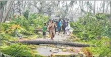  ??  ?? A group of people relocate to safer places as Cyclone Titli hits Barua village in Srikakulam