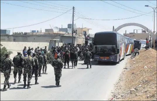  ?? The Associated Press ?? Government forces oversee the evacuation of rebels and their families Saturday from Ruhaiba near Damascus, Syria.