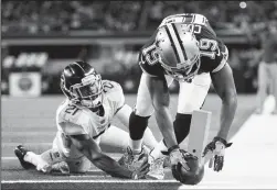  ?? ASHLEY LANDIS/TRIBUNE NEWS SERVICE ?? Dallas Cowboys receiver Amari Cooper (19) scores a touchdown past Titans defensive back Malcolm Butler on Monday.