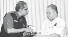  ??  ?? Mohd Roslan (left) presents a memento to Awang Yusof.