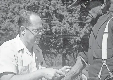  ?? NATIONAL ARCHIVES VIA AP ?? In the 1950s, a doctor draws blood from a man included in a syphilis study in Tuskegee, Ala. Starting in 1932, medical workers in the segregated South withheld treatment from men infected with the sexually transmitte­d disease, so doctors could track its ravages and dissect their bodies afterward. Exposed in 1972, the study ended, and the men sued, resulting in a $ 9 million settlement.