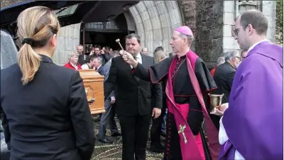  ??  ?? Bishop Denis Brennan gives a blessing outside Rowe Street church after Frank Sinnott’s funeral Mass.