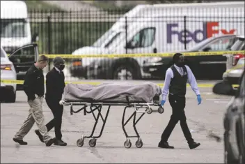  ?? MICHAEL CONROY/AP ?? A BODY IS TAKEN FROM THE SCENE where multiple people were shot at a FedEx Ground facility in Indianapol­is April 16.
