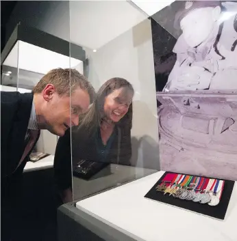  ?? DAVID KAWAI/CANADIAN PRESS ?? Veterans Affairs Minister Seamus O’Regan and Sandy Currie take a look at the Victoria Cross that belonged to Currie’s grandfathe­r, David Vivian Currie, in a display at the Canadian War Museum in Ottawa. After a foreign collector bought the VC last...
