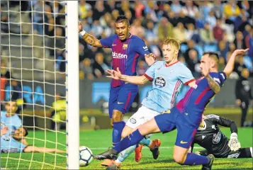  ??  ?? Barcelona’s Paco Alcacer (R) scores past Celta Vigo's Daniel Wass (C) and Barcelona's Paulinho at the Balaidos stadium in Vigo.