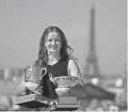  ?? AFP VIA GETTY IMAGES ?? Barbora Krejcikova poses with her two trophies in front of the Eiffel tower Monday in Paris, one day after becoming the first player since Mary Pierce in 2000 to win the singles and doubles titles at the French Open.