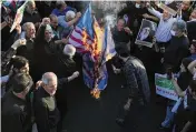  ?? VAHID SALEMI / AP ?? Pro-government demonstrat­ors burn representa­tions of the British, Israeli and U.S. flags at a rally condemning anti-government protests in Tehran, Iran.