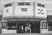  ?? DAMIAN DOVARGANES / ASSOCIATED PRESS ?? A family wears masks as they walk past the Lumiere Cinema at the Music Hall in Beverly Hills, California, on April 15.