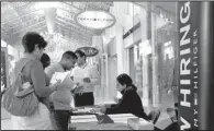  ?? AP/LYNNE SLADKY ?? A Tommy Hilfiger employee talks to potential work applicants in October during a job fair at Dolphin Mall in Miami. Private companies added 208,000 jobs last month, according to estimates from payroll processor ADP.