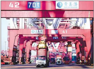  ?? AP file photo ?? Trucks move shipping containers at a port in Qingdao in eastern China’s Shandong province in January. China’s exports rose 11.1 percent in January.