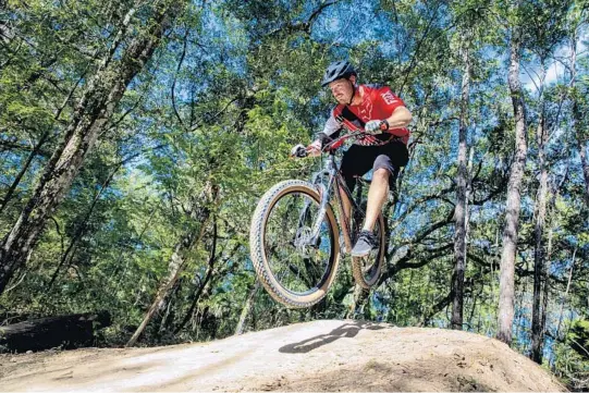  ?? PATRICK CONNOLLY/ORLANDO SENTINEL PHOTOS ?? Austin Story catches some air on Indigo Flow, a section of the Santos trails near Ocala on Friday.