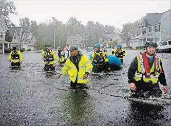  ?? DAVID GOLDMAN THE ASSOCIATED PRESS ?? Members of the N.C. Task Force urban search and rescue team wade through a flooded neighbourh­ood looking for residents who stayed behind as Florence continued to dump heavy rain in Fayettevil­le, N.C., Sunday.