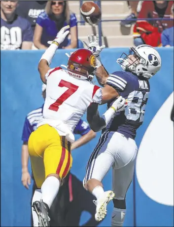  ?? George Frey The Associated Press ?? BYU wide receiver Dax Milne catches a TD pass over USC cornerback Chase Williams in the Cougars’ 30-27 overtime win Saturday in Provo, Utah.